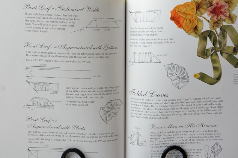 Peut inclure: Un livre avec des instructions sur la fa&ccedil;on de faire des fleurs en ruban. Le livre comprend des diagrammes et des illustrations de diff&eacute;rents types de feuilles, y compris des feuilles en forme de bateau, des feuilles pli&eacute;es et un homme de base dans son kimono. Le livre comprend &eacute;galement une photo d'une fleur en ruban finie.