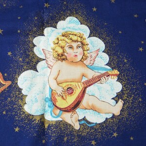 May include: A fabric with a celestial design featuring a cherub playing a lute, set against a dark blue background with gold stars and clouds. Two harps with red bows are also depicted.