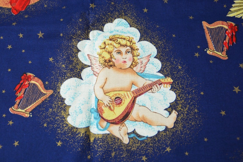May include: A fabric with a celestial design featuring a cherub playing a lute, set against a dark blue background with gold stars and clouds. Two harps with red bows are also depicted.