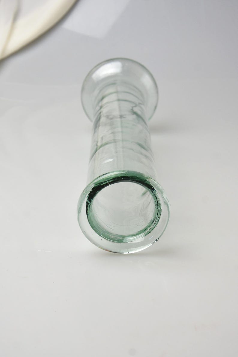 K&ouml;nnte beinhalten: Transparente Glasvase mit breitem, abgerundetem Oberteil und zylindrischem K&ouml;rper. Die Vase hat einen ausgestellten Boden und eine glatte, transparente Oberfl&auml;che. Das Design ist schlicht und elegant, geeignet f&uuml;r Blumen oder als Dekoration.