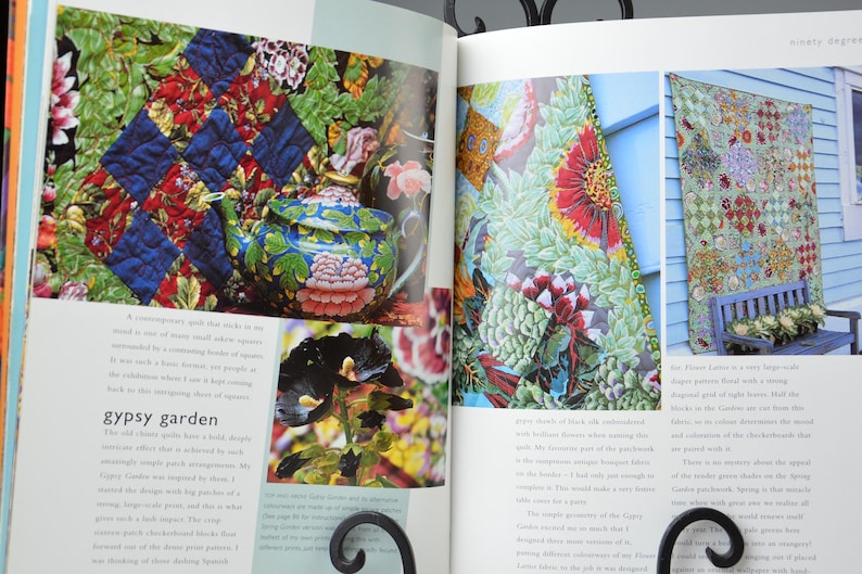 May include: A book spread showcasing quilts and a decorative teapot. The quilts feature detailed floral and geometric patterns. The teapot is blue with floral designs. The page is titled "gypsy garden".