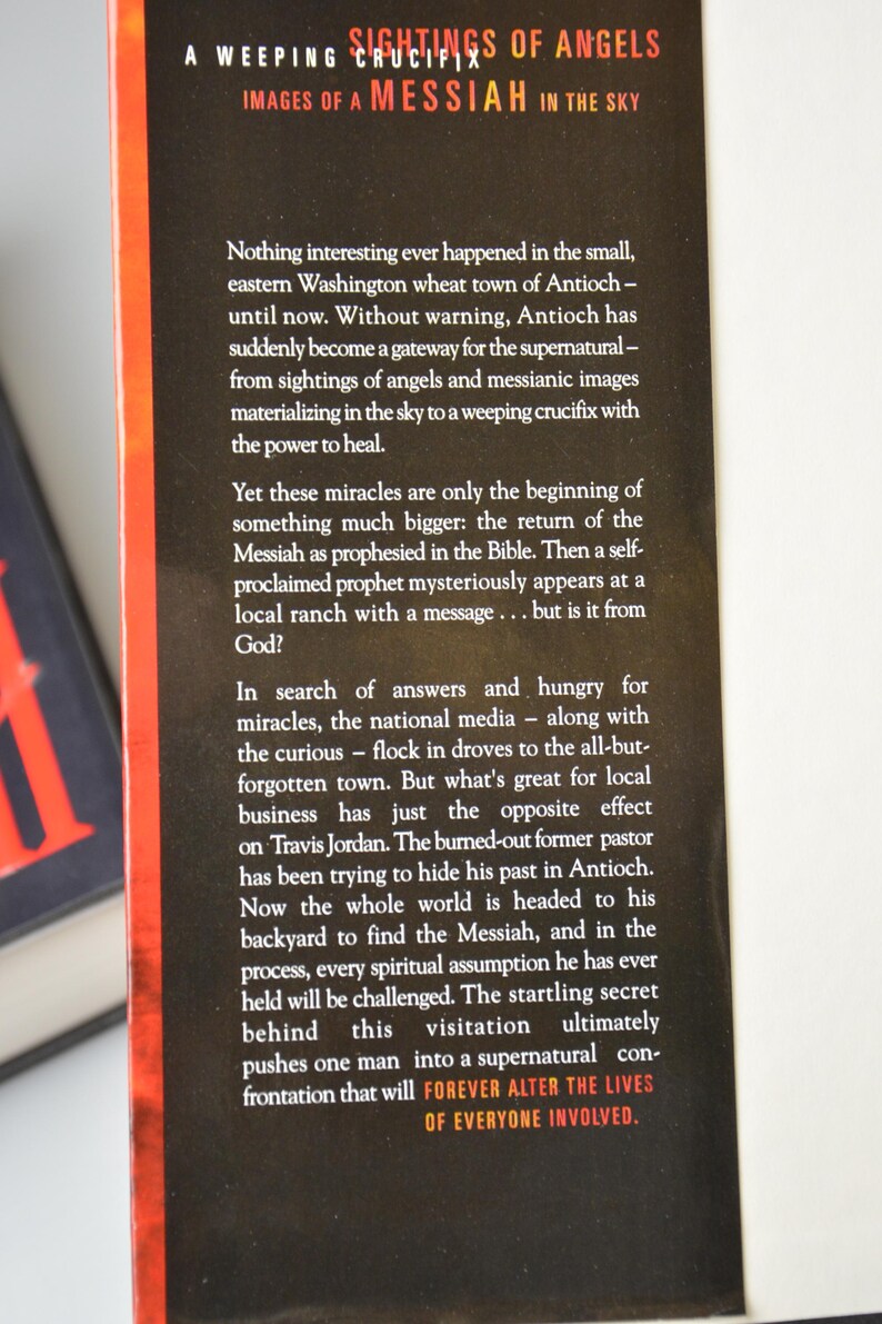 May include: Book cover with the title "Sightings of Angels" and the subtitle "Images of a Messiah in the Sky." The cover has a black background with orange accents and white text. The text describes a supernatural event in Antioch.