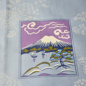 May include: A blue and purple fabric with a white mountain scene, white clouds, and a green tree. The scene is framed in a blue border.