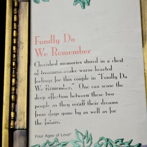 Op de afbeelding: Een ingelijste print met de tekst "Fondly Do We Remember" in rood en zwart. De lijst is goudkleurig met een donkerpaarse rand en groene bladachtige ontwerpen. De tekst beschrijft gekoesterde herinneringen.