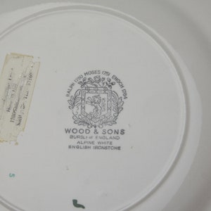 May include: A white ceramic plate with a black and white logo that reads "Ralph 1750 Moses 1751 Enoch 1784", "Wood & Sons", "Burslem England", "Alpine White", and "English Ironstone".