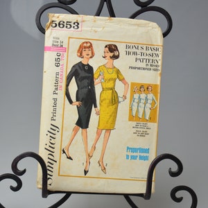 May include: Simplicity sewing pattern number 5653 for a dress in misses' sizes. The pattern includes a bonus basic how-to-sew pattern. The pattern is printed on a yellow background with a black border. The pattern shows two women wearing dresses, one in black and one in yellow.