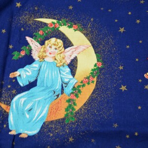 May include: A celestial-themed fabric design featuring a serene angel with blonde hair and blue robes, seated on a crescent moon adorned with roses and holly. A golden harp with a red bow is also depicted against a dark blue starry background.