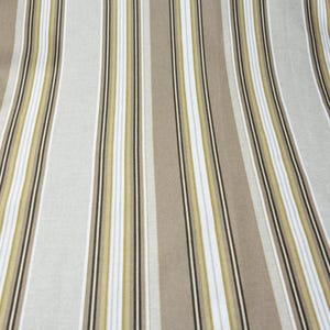 Puede incluir: Tela con rayas verticales en tonos beige, blanco y verde oliva, con finas rayas negras de acento. La tela tiene una ca&iacute;da suave y fluida, lo que sugiere que podr&iacute;a usarse para ropa o decoraci&oacute;n del hogar.