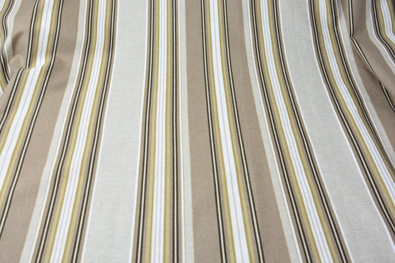 Puede incluir: Tela con rayas verticales en tonos beige, blanco y verde oliva, con finas rayas negras de acento. La tela tiene una ca&iacute;da suave y fluida, lo que sugiere que podr&iacute;a usarse para ropa o decoraci&oacute;n del hogar.