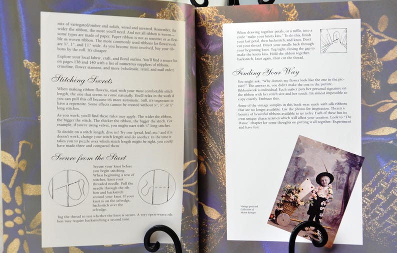 Peut inclure: Livre ouvert avec une couverture &agrave; motif floral color&eacute;. Les pages pr&eacute;sentent des instructions pour la broderie au ruban avec du texte sur "Secrets de couture" et "Trouver votre chemin". Une petite photo d'un enfant dans un jardin se trouve sur la page de droite.