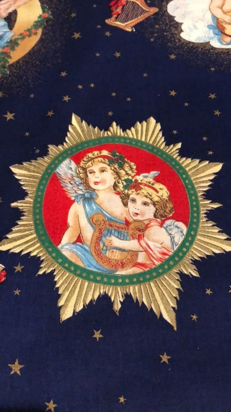 May include: A navy blue fabric with a repeating pattern of gold stars and a central medallion. The medallion features two cherubic figures with wings, one playing a harp, set against a red and green background.