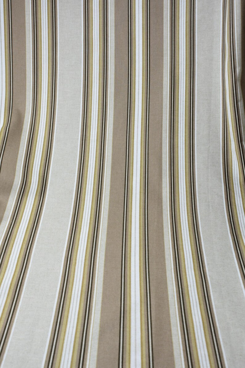 Puede incluir: Tela con rayas verticales en tonos beige, marr&oacute;n, blanco y verde oliva. Las rayas var&iacute;an en ancho, creando una apariencia texturizada. Adecuada para tapicer&iacute;a o decoraci&oacute;n del hogar.