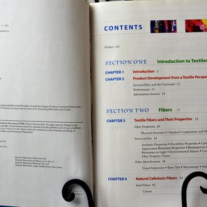 Puede incluir: Un libro titulado "Textiles" con una tabla de contenido que enumera cap&iacute;tulos sobre Introducci&oacute;n a los textiles, Desarrollo de productos desde una perspectiva textil, Fibras textiles y sus propiedades, y Fibras celul&oacute;sicas naturales.