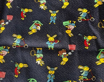 May include: A dark blue fabric with a repeating pattern of yellow rabbits in various poses. The rabbits are wearing different outfits, including a blue uniform, a red and white outfit, and a green outfit. Some rabbits are playing musical instruments, while others are riding scooters.