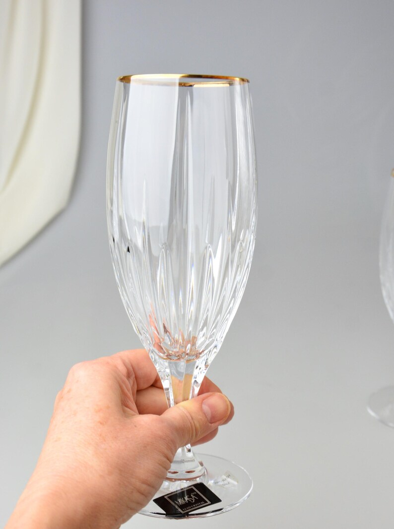 Pu&ograve; includere: Un fl&ucirc;te da champagne trasparente con bordo dorato. Il bicchiere presenta linee incise verticali ed &egrave; tenuto in mano. La base del bicchiere ha un piccolo piede rotondo. Il bicchiere &egrave; elegante e adatto alle occasioni speciali.