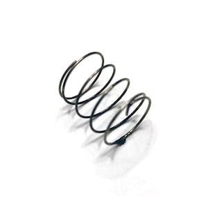 May include: A close-up of a small, coiled metal spring. The spring is dark gray and has several loops, with a slightly irregular shape. The background is plain white, providing a stark contrast to the spring's form.