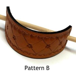 May include: A brown leather hair stick holder with a diamond pattern and a wooden stick. The holder is labeled "Pattern B".