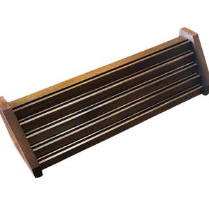 May include: A rectangular wooden tray with multiple horizontal slats. The tray is made of dark brown wood and has a simple, minimalist design. The slats are evenly spaced, creating a grid-like pattern. The tray is ideal for organizing items.