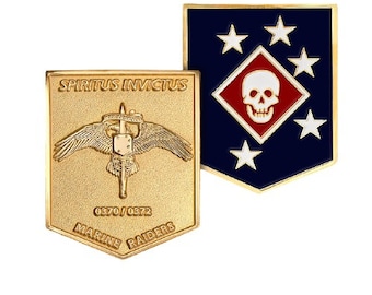 May include: Two military-style pins. One is gold-colored with the words "SPIRITUS INVICTUS" and "MARINE RAIDERS", and a central emblem. The other is navy blue with white stars and a red and white skull emblem.
