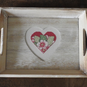 Peut inclure: Un plateau en bois avec une découpe en forme de cœur présentant un motif de broderie florale dans des tons de rouge, rose et vert.