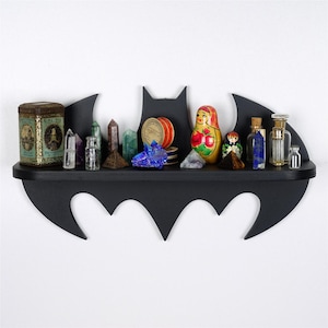 May include: A set of three ceramic mugs with a speckled, matte finish. The mugs are in shades of cream, light brown, and dark brown. Each mug has a simple, minimalist design and a rounded handle.