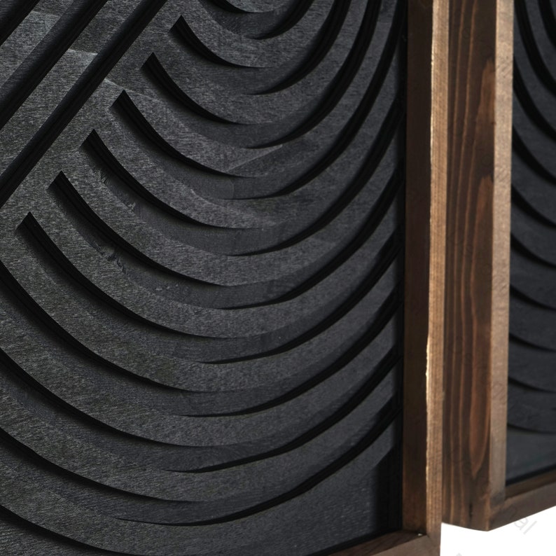 May include: Two black wood wall panels with a geometric pattern of curved lines. The panels are framed in dark wood.