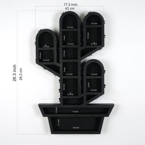 May include: Black cactus-shaped wall shelf, 26.3 inches tall and 17.2 inches wide. Features multiple shelves of varying sizes, including 3.2 inch and 3.8 inch depths. The shelf is designed to resemble a cactus in a pot, with a 9.6 inch wide base.