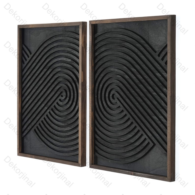 May include: Two black wood wall decor panels with a geometric design of concentric circles and lines. The panels are framed in dark wood.