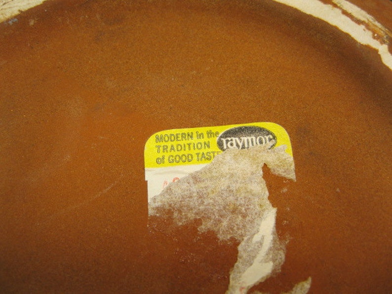 May include: A yellow sticker with the text "MODERN in the TRADITION of GOOD TASTE" and the word "raymor" in black lettering.