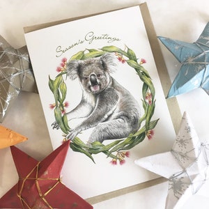 Tarjeta navideña con koala y corona de hojas de eucalipto australianas, flores silvestres, tarjeta navideña, saludos de temporada, saludo de animal australiano, tarjeta única