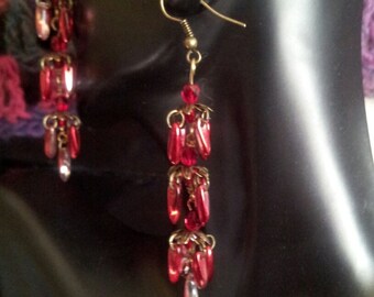 Chandelier style earrings with red glass daggers and antique brass elements