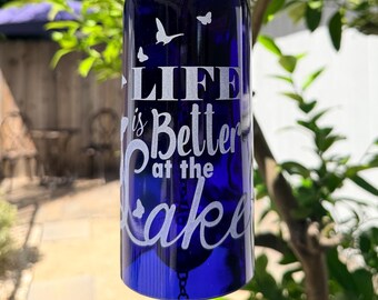 La vida es mejor en el lago. Campana de viento con mariposas hecha con una botella de vino reciclada.