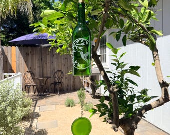 Campana de viento con flores y colibríes hecha con una botella de vino reciclada.