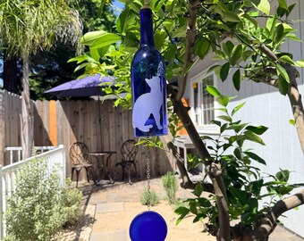 Campana de viento con forma de mariposa y gato hecha con una botella de vino reciclada.