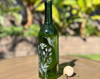 Carillón de viento con forma de colibrí y flores silvestres, hecho con botellas de vino recicladas