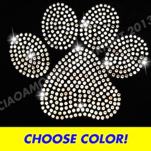 May include: A large silver paw print design made of rhinestones.  The paw print is made up of five circles of rhinestones.  The design is on a black background.  Choose Color!