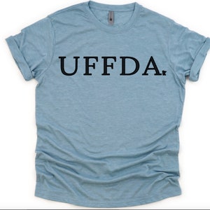 May include: A light blue t-shirt with the word "UFFDA." printed in black.
