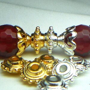 May include: Close-up of gold and silver metal bead caps with a decorative design. The caps are used for jewelry making and crafting.