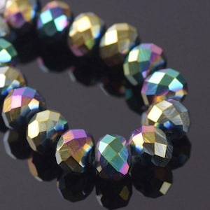 May include: A strand of iridescent faceted glass beads in shades of blue, green, and gold. The beads are round and have a textured surface.