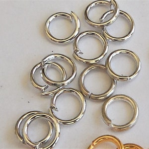 Op de afbeelding: Een close-up van een stapel zilveren springringen. De ringen zijn allemaal even groot en gemaakt van metaal.