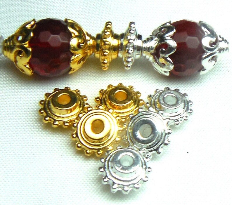 May include: Gold and silver metal bead caps with a decorative, scalloped edge. The bead caps have a small hole in the center for threading.