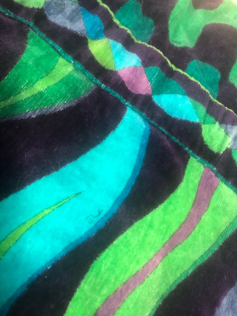 May include: Close-up of a dark blue and green fabric with a wavy pattern. The fabric has a soft, velvety texture. The word "Dundee" is written in white on the fabric.