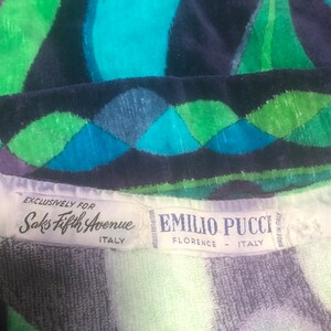May include: A white label with black text that reads "Exclusively for Saks Fifth Avenue Italy" and a white label with black text that reads "100% Pure Cotton Emilio Pucci Florence - Italy Made in Italy" on a blue, green, and white patterned fabric.