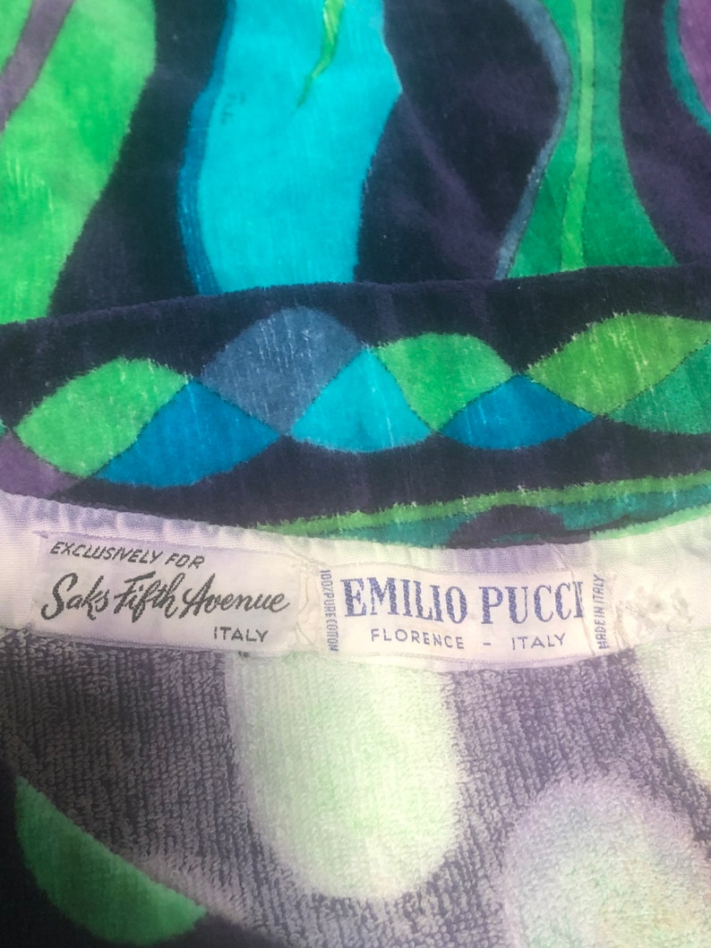 May include: A white label with black text that reads "Exclusively for Saks Fifth Avenue Italy" and a white label with black text that reads "100% Pure Cotton Emilio Pucci Florence - Italy Made in Italy" on a blue, green, and white patterned fabric.