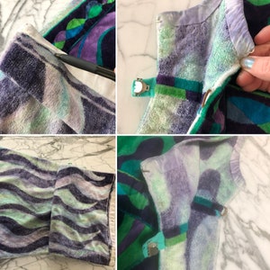 May include: Close-up of a green, purple, and white patterned towel with a silver clip. The towel is folded in half and the clip is attached to the edge of the towel.