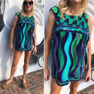 May include: A sleeveless, blue, green, and purple patterned, short, vintage, beach cover-up with a geometric design.