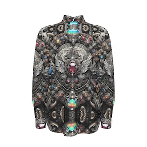 May include: A long-sleeved button-up shirt with a black background and a detailed pattern of silver, gold, and colourful jewels. The pattern features a central design of a shield with wings and a large red jewel.