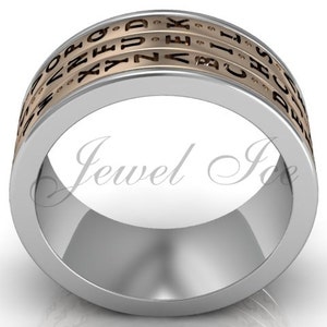 May include: A silver ring with three rotating bands featuring engraved letters. The bands are a light gold colour, and the ring has the text "Jewel Ice" on the inside.