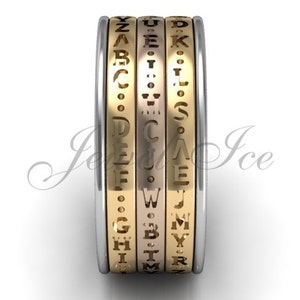 May include: A gold and silver ring with a rotating band featuring the alphabet in a unique font.