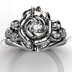 Puede incluir: Un anillo de compromiso de plata en forma de rosa con un gran diamante central y diamantes m&aacute;s peque&ntilde;os engastados en los p&eacute;talos. El anillo est&aacute; dise&ntilde;ado para ser usado con una banda de boda a juego.